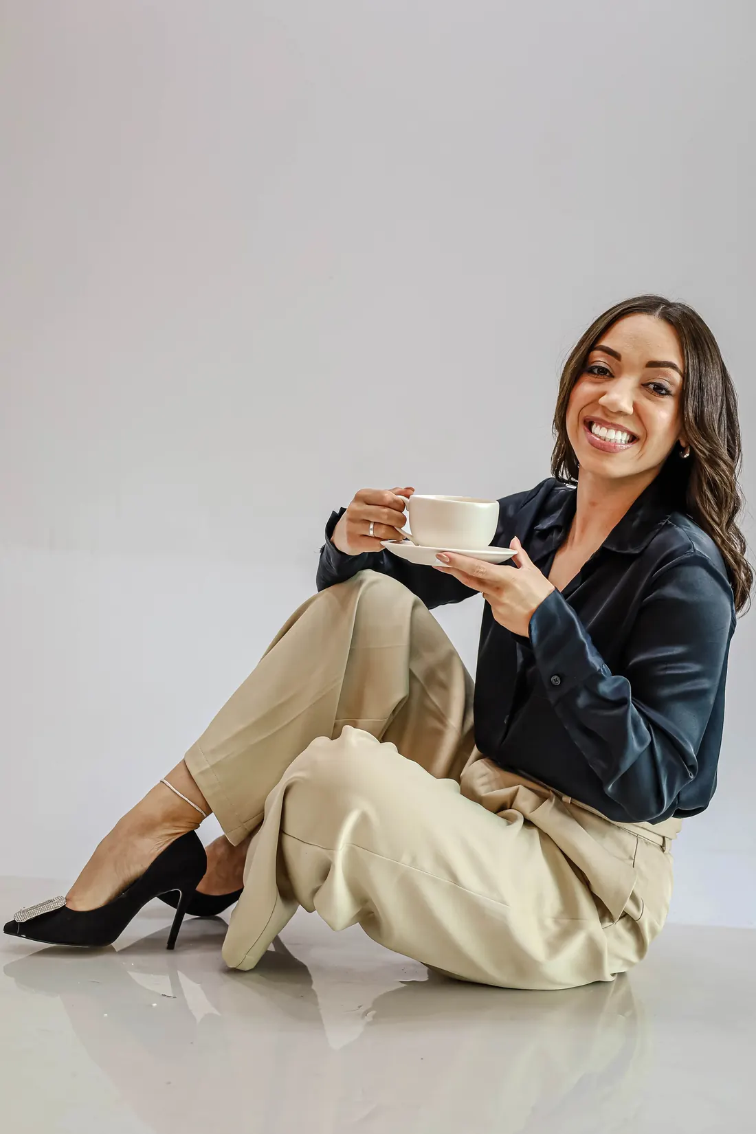 Thayna Souza sentada com uma xícara de café